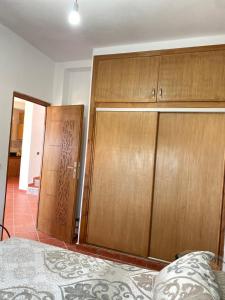 a bedroom with two wooden cabinets and a bed at Awechtam house in Aouchtame