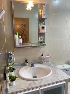 een badkamer met een wastafel en een spiegel bij Awechtam house in Aouchtame