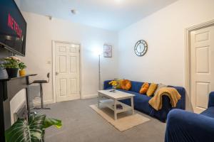 a living room with a blue couch and a table at 2 Bedroom Apartment-Free Parking-Private Entrance in Gateshead