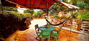 una mesa y sillas bajo una sombrilla en un patio en Cabaña del Vitruvio cerca termales de Paipa en Paipa