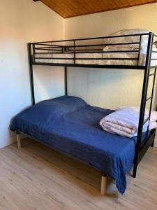 a bunk bed in a room with a blue bedsheet at T3 à port leucate climatisé 50m de la plage in Port Leucate