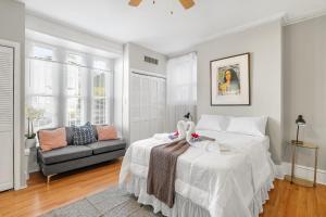 um quarto branco com uma cama e um sofá em Modern Posh Upenndrexel Univ 3 Bdrm em Filadélfia