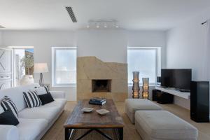 a living room with a couch and a fireplace at Villa Delilah - Paradise Estate Mykonos - Views, Party, Memories 2026 in Paraga