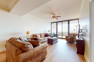 sala de estar con muebles de cuero y ventilador de techo en Holiday Isle 413 en Dauphin Island