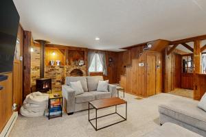 a living room with a couch and a tv at Jay Peak Getaway on Trout River in Montgomery