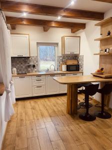 a kitchen with white cabinets and a wooden table at Sielankowe Pole in Józefów