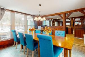 una sala da pranzo con tavolo in legno e sedie blu di Jay Peak Getaway on Trout River a Montgomery