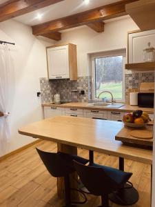 a kitchen with a wooden table and a window at Sielankowe Pole in Józefów