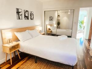 Sunkissed Boho Hilltop Haven Apartment في سان دييغو: غرفة نوم بسرير كبير ومرآة