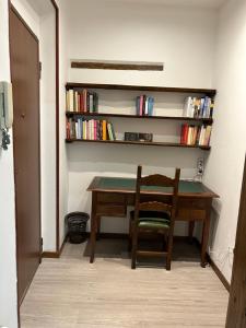 escritorio con silla y estantería con libros en Larocca Tourist Home 3, en Bassano del Grappa