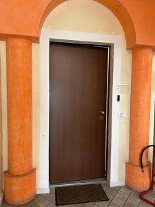 una puerta marrón en medio de un edificio en Larocca Tourist Home 3, en Bassano del Grappa