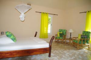 1 Schlafzimmer mit einem Bett, 2 Stühlen und einem Fenster in der Unterkunft Nino Ranch Lodge 