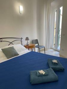 um quarto com uma cama azul com duas toalhas em Le case di Cate e Max - Luna em Florença