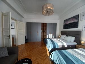 a bedroom with two beds and a couch and a chandelier at Apartment Hesperia in Zagreb