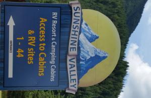 a large sign with a mountain on it at Sunshine Valley RV Resort and Cabins in Sunshine Valley