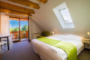 ein Schlafzimmer mit einem großen Bett und einem Fenster in der Unterkunft Holiday Home Holiday Raj in Bešeňová