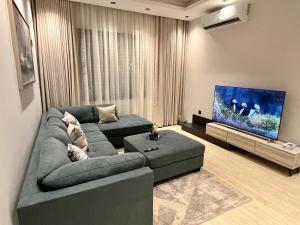a living room with a couch and a flat screen tv at Safa Complex Apartment in Riyadh