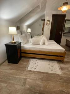 a bedroom with a bed with white sheets and a lamp at Apartament Yannis in Alba Iulia