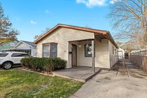 a house with a porch and a car parked in front at Cozy 3BR Home Friendly City of Hazel Park in Hazel Park