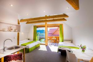 a room with two beds and a kitchen with a sink at Holiday Home Holiday Raj in Bešeňová