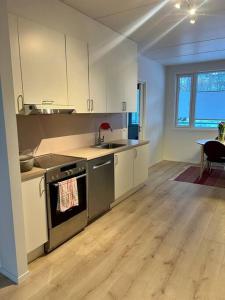 uma cozinha vazia com um lavatório e um fogão em Modern apartment nearby city centrum em Tromsø