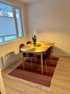 uma mesa de jantar com cadeiras e um vaso de flores em Modern apartment nearby city centrum em Tromsø