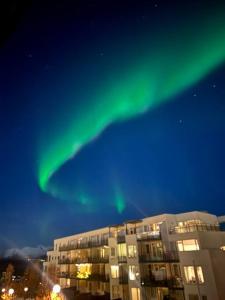 um edifício de apartamentos com as luzes verdes do norte no céu em Modern apartment nearby city centrum em Tromsø