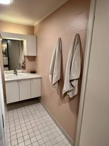 uma casa de banho com lavatório, espelho e toalhas em Modern apartment nearby city centrum em Tromsø