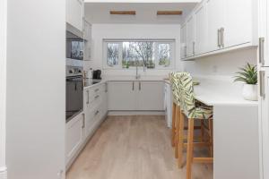 a kitchen with white cabinets and a table and chairs at 82 Van Road in Caerphilly