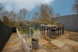 a patio with a table and chairs and a fence at 82 Van Road in Caerphilly