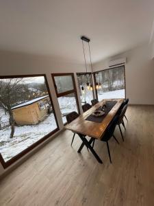 ビシェウ・デ・ススにあるBiutiful Bungalowのダイニングルーム(木製テーブル、大きな窓付)