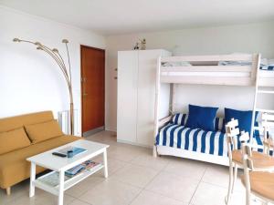 a living room with a couch and a bunk bed at T1 bis neuf avec petite chambre à 150m de la plage in La Baule