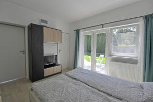 a bedroom with a bed and a sliding glass door at Villa Oliver 1 Siófok in Siófok