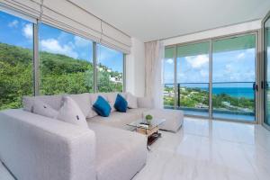 un soggiorno con divano bianco e ampie finestre di Oceana Sea View - Kamala Beach a Kamala Beach