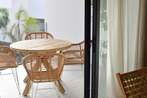 einen Holztisch und Stühle auf einem Balkon mit einem Tisch in der Unterkunft Luxury aparment in casilla de costa with Jacuzzi- Follow the sun in La Oliva