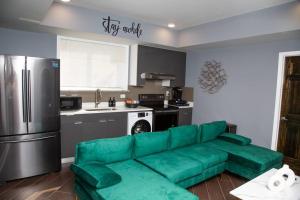 a living room with a green couch in a kitchen at Lux Stay by Center City/Temple in Philadelphia