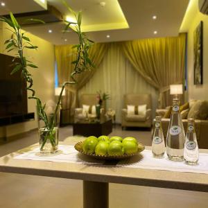 a table with a bowl of green apples on it at ريحانة 2 - Raihana 2 Hotel in Jeddah