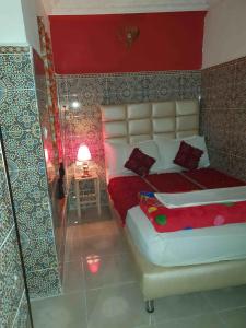 a bedroom with a large bed with a red wall at Riad 112 in Marrakesh