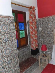 Habitación con ventana y mesa con lámpara. en Riad 112, en Marrakech