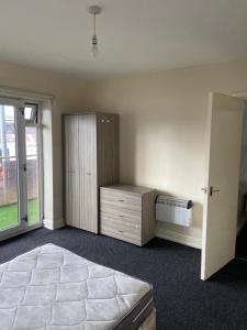 a bedroom with a bed and a dresser and a window at Cosy living in Camberley