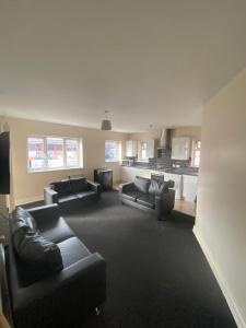 a living room with two couches and a kitchen at Cosy living in Camberley
