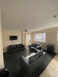 a living room with couches and a flat screen tv at Cosy living in Camberley