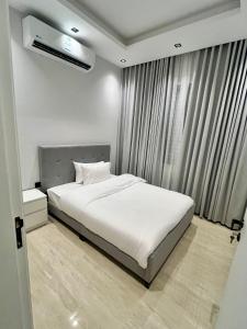 a bedroom with a white bed and a window at Safa Complex Apartment in Riyadh
