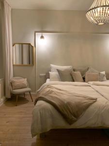 a bedroom with a large bed and a chair at Quedlinburg Marktplatz-Suites in Quedlinburg