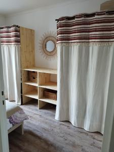 Habitación con 2 cortinas y mesa con espejo. en The doudou's house en La Queue-lès-Yvelines