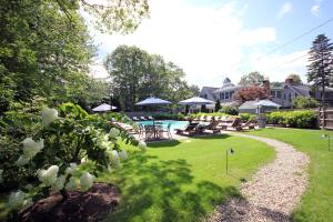 a yard with a pool and tables and chairs at Cape Arundel Inn - Club House in Kennebunkport
