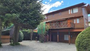 Cette grande maison en bois possède un balcon. dans l'établissement Bellavista, à Villa La Angostura