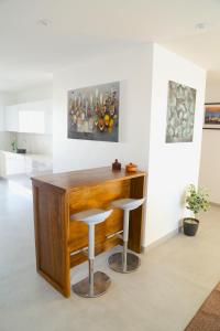 a kitchen with a wooden bar with two stools at Résidence Théa in Dakar