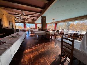 Un comedor con mesas y sillas y ventanas. en Hotel Belmont, en Crans-Montana