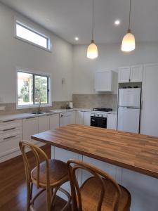 a kitchen with a wooden table and two chairs at Greenhills Guesthouse in Victor Harbor